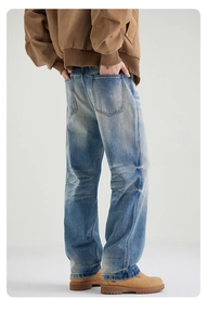 Detailed close-up of light blue stonewashed denim with vintage cat whiskers texture