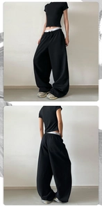 Λεπτομέρεια από τη μέση με κορδόνι και την πίσω τσέπη του μαύρου φαρδιού παντελονιού