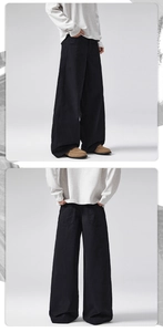 Detail view of baggy black high street trousers with wide-leg cut and premium cotton texture