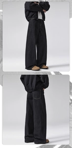 Detail of high-weight black denim jeans with yellow contrast stitching and wide-leg fit