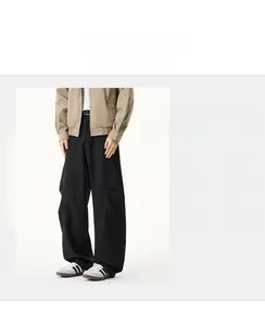 Détail du pantalon noir à taille haute avec une coupe large et un design décontracté