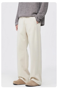Détail d'un pantalon large blanc cassé avec un drapé premium et des plis à la taille