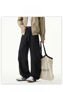 Détail du pantalon cargo noir à coupe courbée avec jambes larges et poches latérales