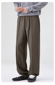 Détail de pantalon homme vert olive à coupe droite avec plis et beau tombé fluide