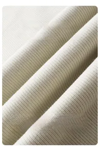 Détail macro de la texture du tricot côtelé blanc crème avec une grande élasticité et douceur