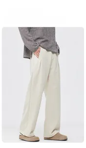 Détail du pantalon large blanc cassé à taille haute avec plis élégants sur le devant