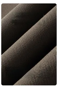 Vue macro détaillée de la texture du tissu en sergé marron foncé pour pantalon de luxe