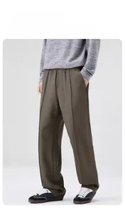 Détail d'un pantalon droit vert olive avec taille élastique et pli marqué
