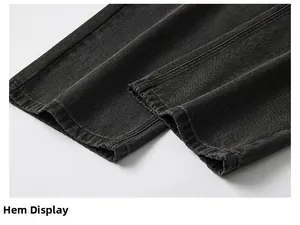 Vue détaillée du revers de jean baggy montrant la texture denim noir délavé et les coutures