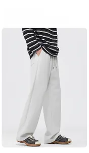 Detail view of the drawstring elastic waist and side pockets on beige wide-leg trousers