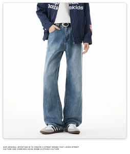 Jean large délavé bleu moyen porté avec veste à rayures et baskets style urbain