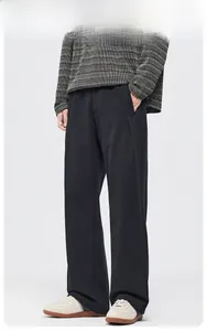 Pantalon droit en polaire pour homme noir, porté avec un pull gris et des baskets