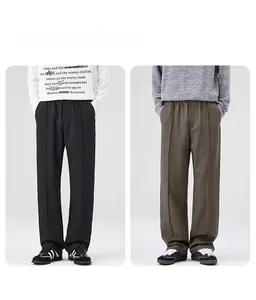 Vue détaillée du pantalon droit en noir et vert olive avec plis verticaux marqués