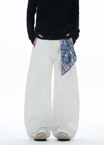 Détail d'un pantalon streetwear blanc à jambes larges avec coutures incurvées et coupe ample