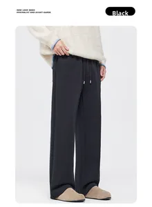 Detail view of black wide-leg joggers featuring elastic drawstring waist and side seam detail