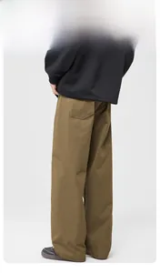 Detail of loose-fit brown cargo pants back pocket and cotton twill fabric texture