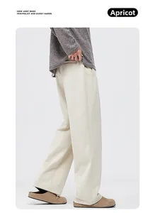 Vue latérale du pantalon large droit abricot montrant le tissu drapé et la poche invisible