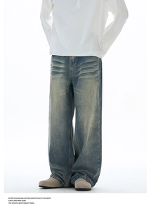 Detail shot of vintage washed wide-leg jeans featuring 3D whiskers and distressed finish