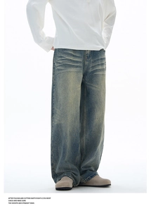 Detail of wide-leg jeans featuring vintage washed blue finish and whisker design
