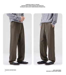 Vue détaillée du pantalon vert olive à coupe large avec un drapé et une texture élégante