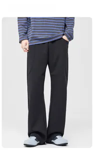 Gros plan du pantalon large noir avec coutures verticales et boutons sur le mannequin
