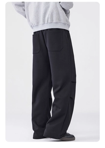 Detailansicht der großen Tasche und des dicken Strickstoffs der schwarzen Herren-Wide-Leg-Hose