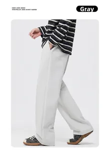 Detail of light grey straight-leg casual trousers showing the relaxed drape and fabric texture