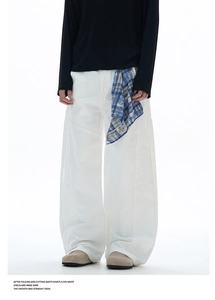 Détail de coutures contrastées sur pantalon large blanc avec foulard à carreaux bleu