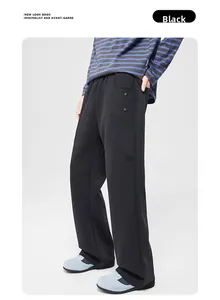 Détail du pantalon en maille noire avec taille élastique et poches à boutons-pression
