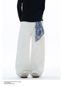 Détail du pantalon large blanc avec accessoire à carreaux amovible et coutures apparentes
