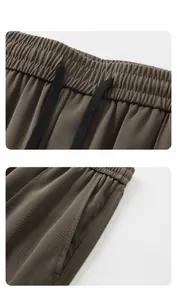 Détail d'un pantalon décontracté marron foncé avec taille élastique à cordon et poches