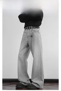 Detail einer hellgrauen Wide-Leg-Jeans mit dekorativer Kugelkette und schwarzem Gürtel