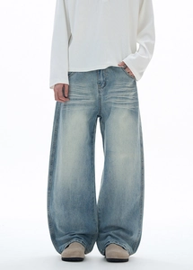 Détail d'un jean vintage bleu ample avec moustaches et texture de denim délavé rétro