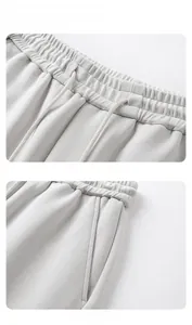 Detail view of elastic drawstring waist and side pockets on light grey knit casual pants