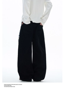 Détail de l'arrière d'un pantalon noir large avec deux poches plaquées et une coupe ample moderne