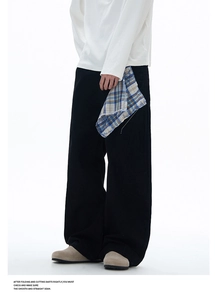 Détail d'un pantalon noir à jambe large avec pochette à carreaux amovible et coutures
