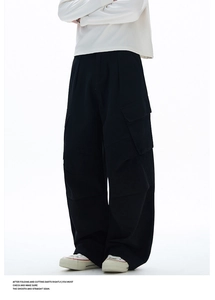Dettaglio dei pantaloni cargo neri a gamba larga con grandi tasche laterali in cotone