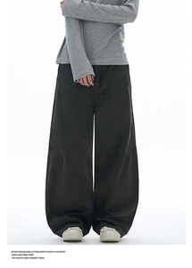 Detail of charcoal grey wide-leg pants featuring structural pleated seams and 3D cut