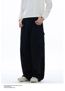 Dettaglio dei pantaloni cargo neri in cotone con tasche utility e taglio dritto