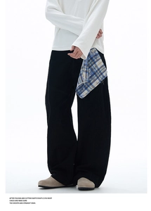Détail du pantalon noir ample avec un foulard à carreaux jaune et bleu à la taille