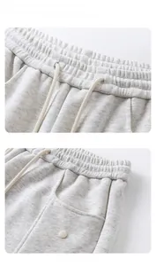 Détails du pantalon de jogging gris avec taille à cordon et poches avant boutonnées