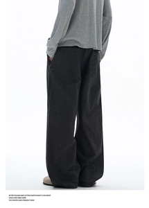 Macro detail of washed charcoal wide-leg trousers featuring large back square pockets