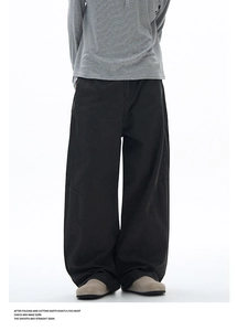 Detail of black wide-leg trousers showing heavy twill fabric and knee darts construction