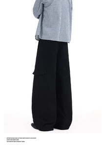 Detail view of black cargo pants showing the oversized flap pocket and stitched seams