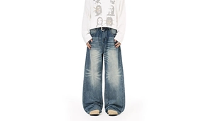 Detailed view of American vintage wide-leg denim jeans with starburst whiskering and wash