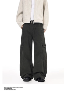Detail view of large side flap pockets on dark grey washed wide-leg cargo pants