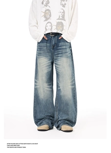 Detail view of vintage wash textures and whiskers on high street wide leg denim jeans