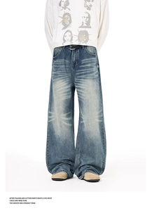 Detail of vintage washed denim jeans showing cat-scratch texture and loose fit style