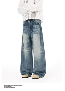 Detail of vintage washed wide-leg jeans with cat-whisker effect and distressed denim fabric