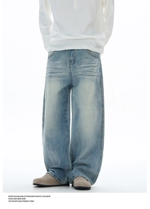 Détail d'un jean bleu clair à jambe large avec délavage vintage et coupe ample pour hommes